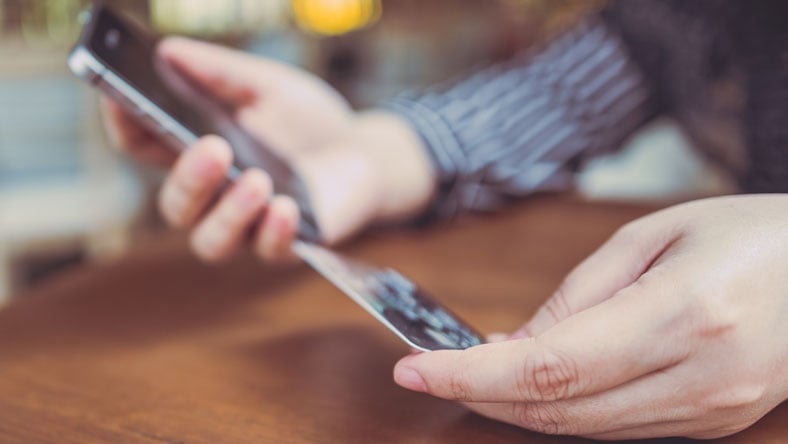 A man entering information from his credit card on his phone