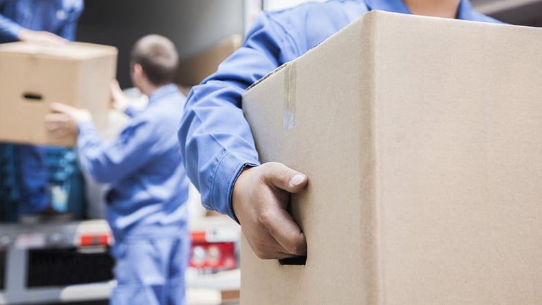 A group of men moving boxes off a truck