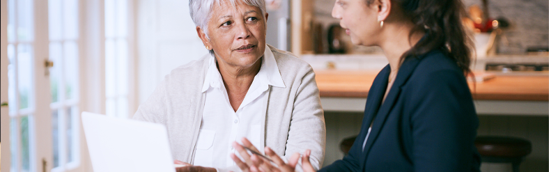 Financial representative talking with mature person at laptop