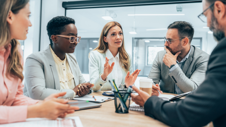 Business colleagues sitting at meeting table having a discussion